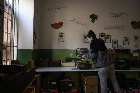 Una mujer pesa la fruta en el local de un grupo agroecológico en Tetuán (Madrid). Álvaro Minguito